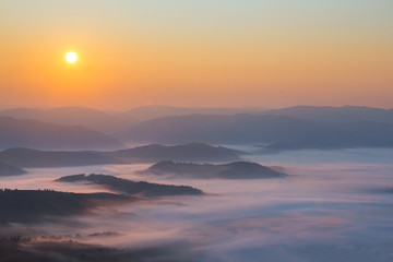 Fototapeta premium early morning, sunrise above a mountain valley in the mist