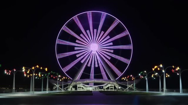 Ferris wheel on the boulevard in Baku, near the Caspian Sea, shot in the evening on a long exposure, with color lighting effects. Azerbaijan.Timelapse video