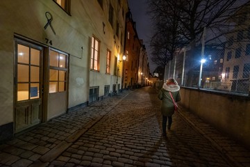 Frau alleine nachts in der Altstadt von Gamla Stan, Stockholm, Schweden