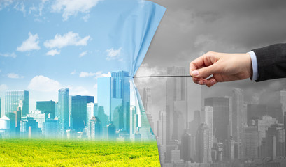 hand pulling green cityscape curtain to gray cityscape, environmental protection concept
