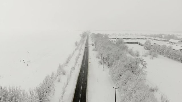 Drone 4K aerial footage of village covered with snow. White cloudy winter weather.