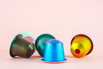 Colorful collection of espresso coffee machine capsules  on pink background.