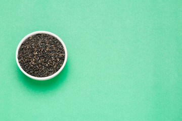 Black organic seeds of sesame - Sesamum indicum. Green background