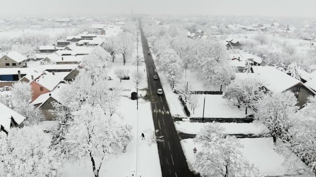 Drone 4K aerial footage of village covered with snow. White cloudy winter weather.