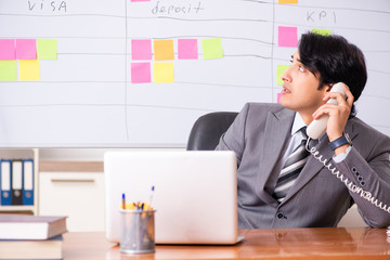 Young handsome employee working in the office