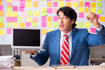 Young handsome employee with many conflicting priorities 