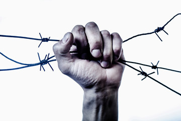 Mans hand with a barbed wire as symbol of fight for freedom.