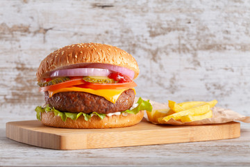 Hamburger with french fries on wooden board