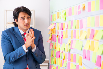 Young handsome employee with many conflicting priorities 