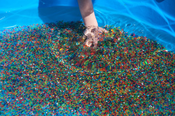 multicolored water beads in child's hands
