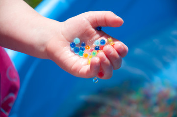 child holding water beads