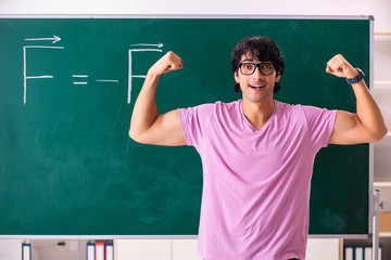 Young male physic standing in front of the green board