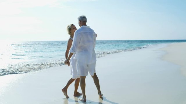Loving senior couple walking on beach vacation Bahamas