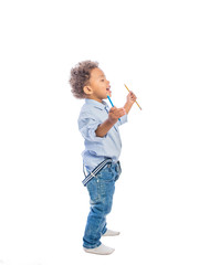 Black child with pencils in his hands looks away from him on an isolated background