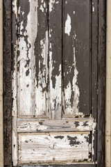 Close-up photo. A fragment of a wooden door with a broken color.