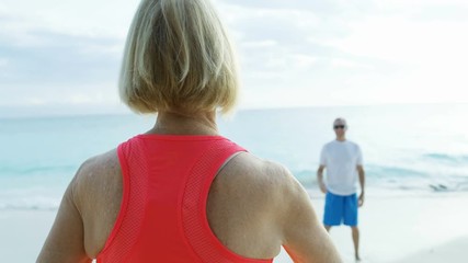 Happy senior American couple playing Frisbee toy Bahamas  - Powered by Adobe