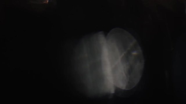 The dim, lonely defocused flare slowly floats in the dark.