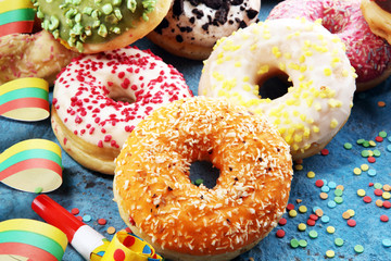 assorted donuts with chocolate frosted, pink glazed and sprinkles donuts