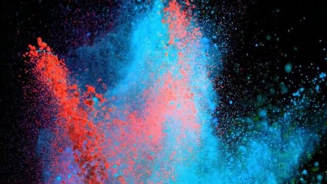 Super slowmotion shot of color powder explosions isolated on black background.