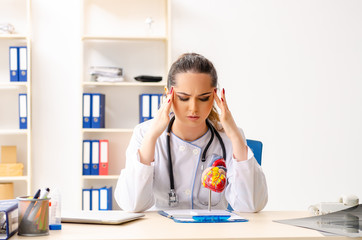 Young female doctor cardiologist sitting at the hospital 