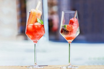 Transparent glasses of wine, popsicles, watermelon, strawberry, blackberry and mint