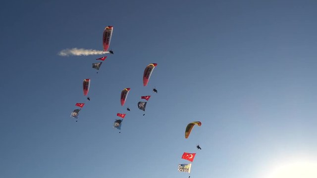 Fethiye, Turkey - 19th of October 2017: International Air Games on the Calis beach - 4K Paramotors with flags are coming to the beach, a man with model plane in his hands 