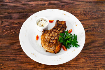 pork chop with vegetables in a white plate