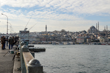 Fototapeta na wymiar People fishing in Galata bridge and Istanbul view at the back