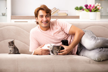 Young man playing with kitten at home