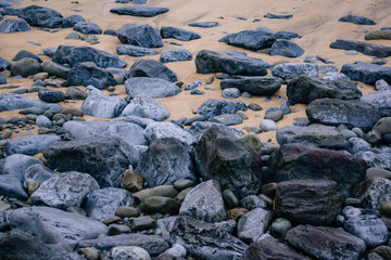 Fototapeta na wymiar Smooth sand beach with rocks