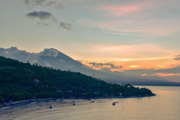 Top view of Amed beach and volcano Agung at sunset. Bali, Indonesia
