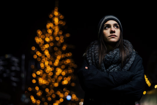 Night portrait of a sad woman feeling alone and depressed in winter.Winter depression and loneliness concept