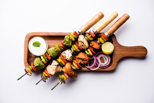 Chicken Hariyali kakab or Malai malai kebab served with skewers and yogurt dip in a plate. selective focus