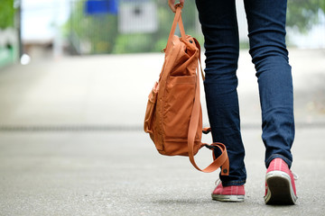 Back of student girl holding school bag while walking in school campus background, education, back...