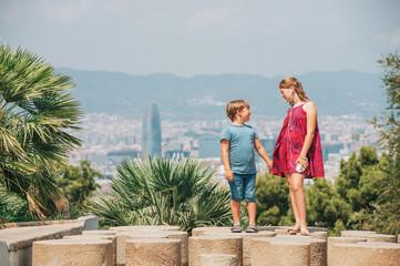 Cute little children tourists admiring Barcelona city from Montjuic hill, travel with kids