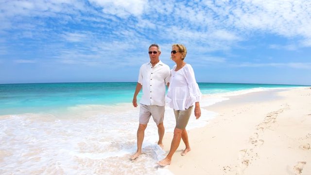 Loving senior couple walking on beach vacation Bahamas