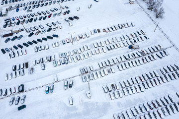 aerial view of parking cars covered with snow. drone photo from above