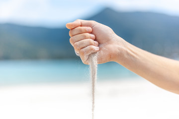 Beach trip vacation tropics concept, white sand strewed from female hands © olezzo