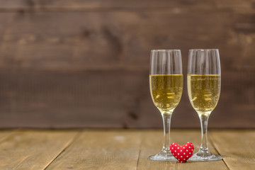 Pair glass of champagne with heart on wooden background. Empty space for your text. Valentine day concept