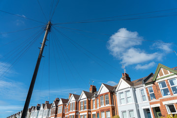 Old vintage wood telephone poles cable construction style in townhouse area in UK. Pylon, power...