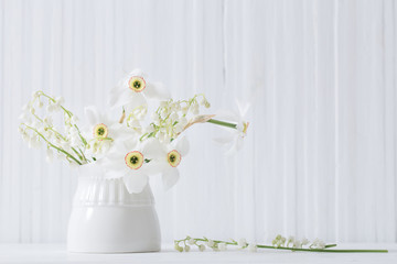 spring flowers in vase on white wooden background