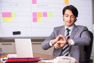 Young handsome employee working in the office