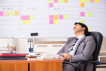 Young handsome employee working in the office