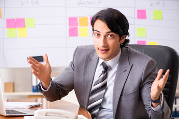 Young handsome employee working in the office