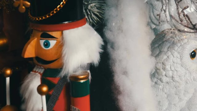 Wooden figures of fairy-tale nutcrackers and white owls spinning on the window of the Christmas market with a price tag and discount