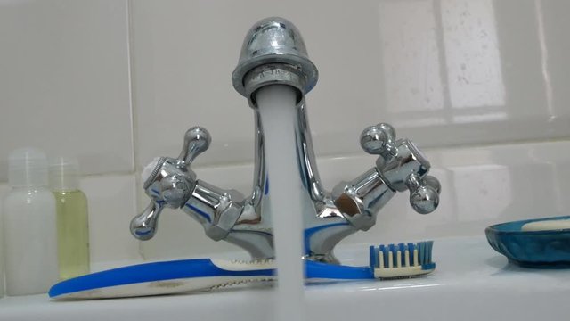 Clean water flows from the chromed metal tap. Running water. Representing water wastage. Plumbing equipment for home.
