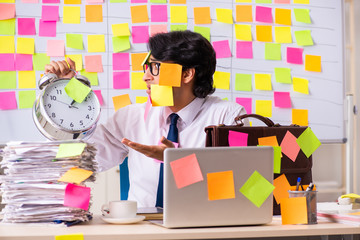 Young employee in conflicting priorities concept 