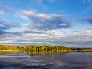 Fototapeta na wymiar clouds over a forest lake