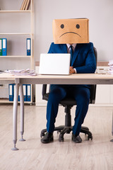 Unhappy man employee with box instead of his head 
