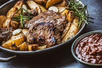 Beef grilled steaks with barbecue sauce roasted potatoes and rosemary